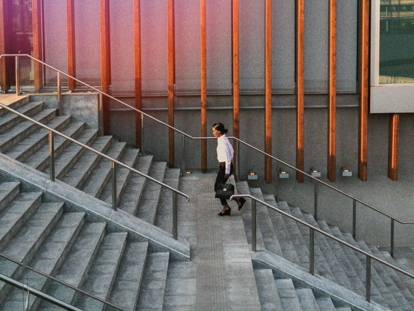 Professional walking through a modern enterprise campus staircase